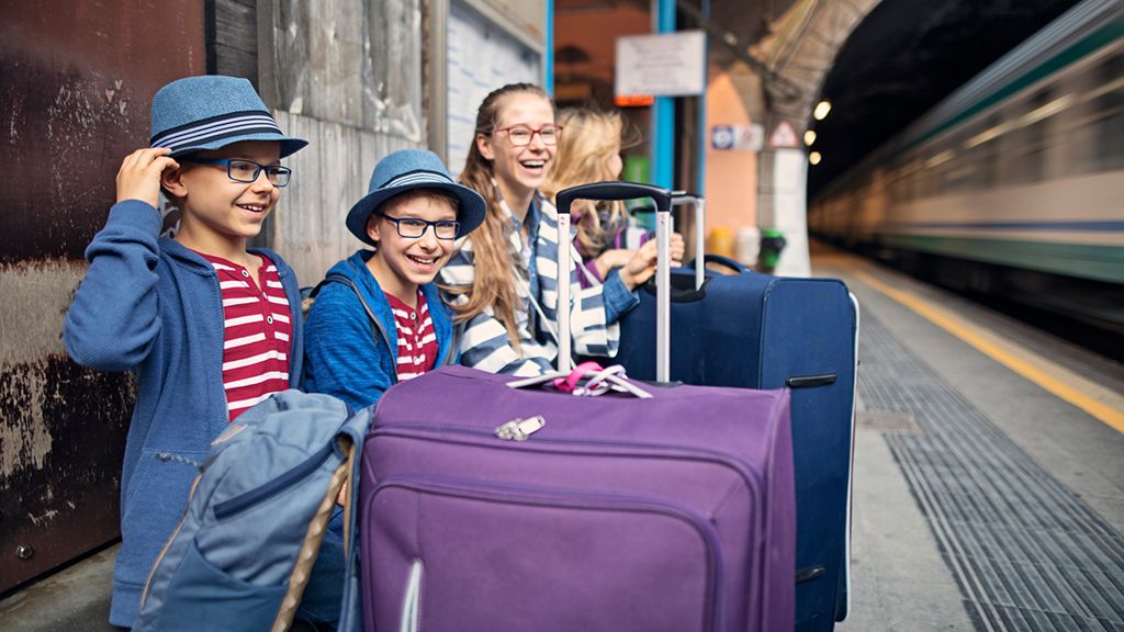 Rodzina z dziećmi z walizkami na peronie - zniżki z Kartą Dużej Rodziny na PKP