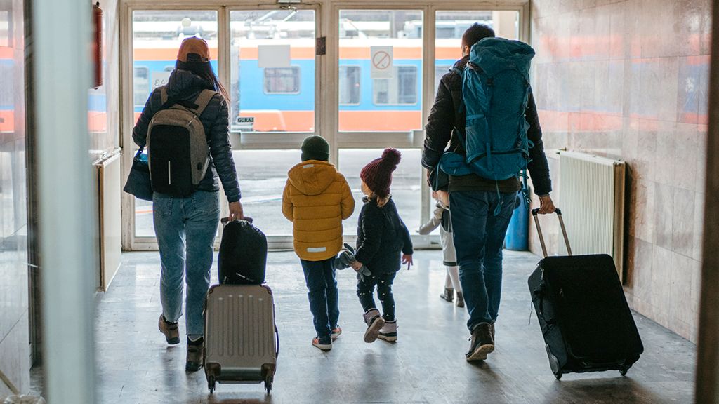 Rodzice z dziećmi w drodze na peron z walizkami