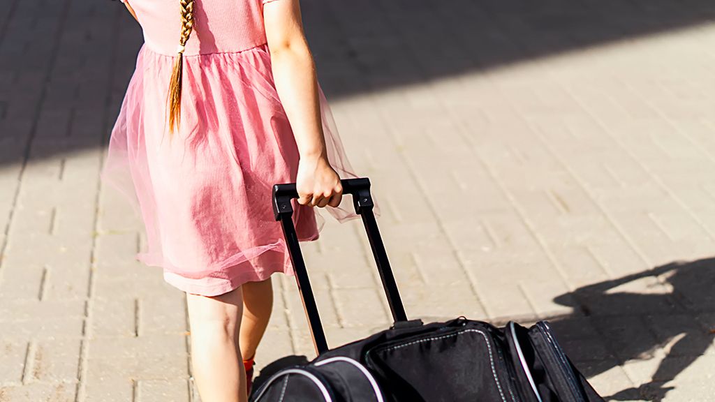 Dziewczynka ciągnąca walizkę - od ilu lat można jeździć samemu pociągiem