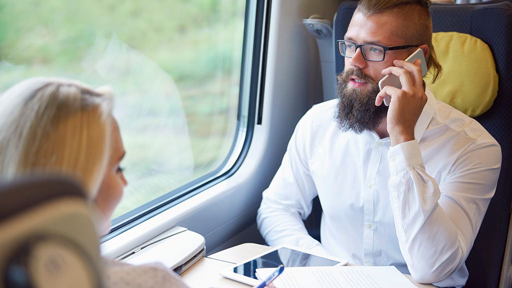 Mężczyzna rozmawiający przez telefon w pociągu