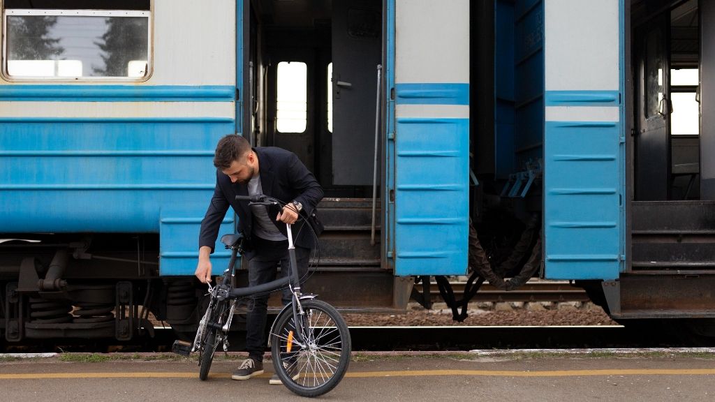 mężczyzna z rowerem przed pociągiem