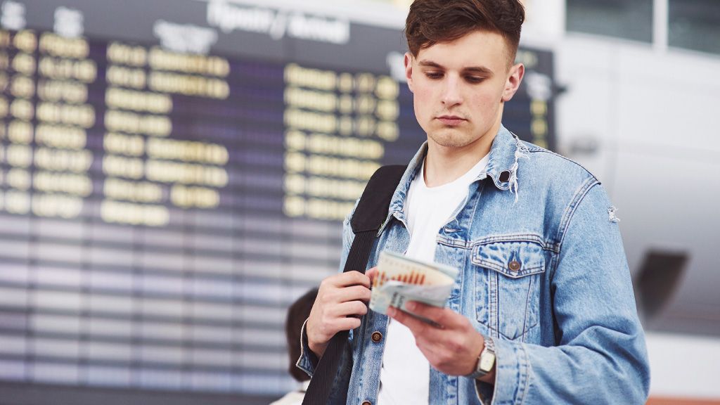 Młody człowiek z biletem na pociąg na dworcu