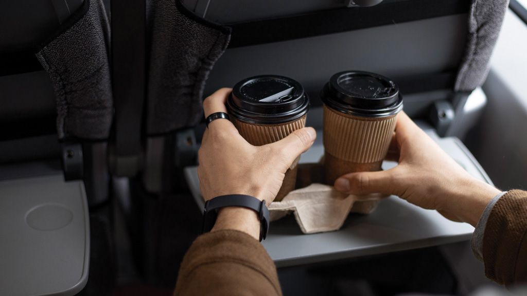 Mężczyzna trzymający kawy w pociągu